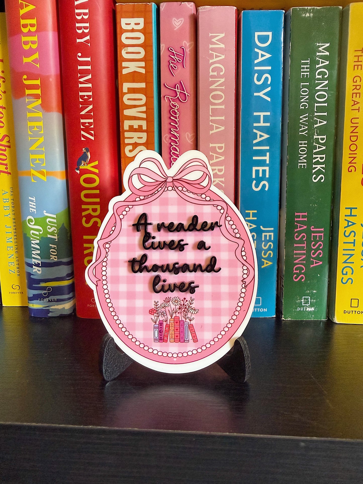 “A reader lives a thousand lives” bookshelf sign