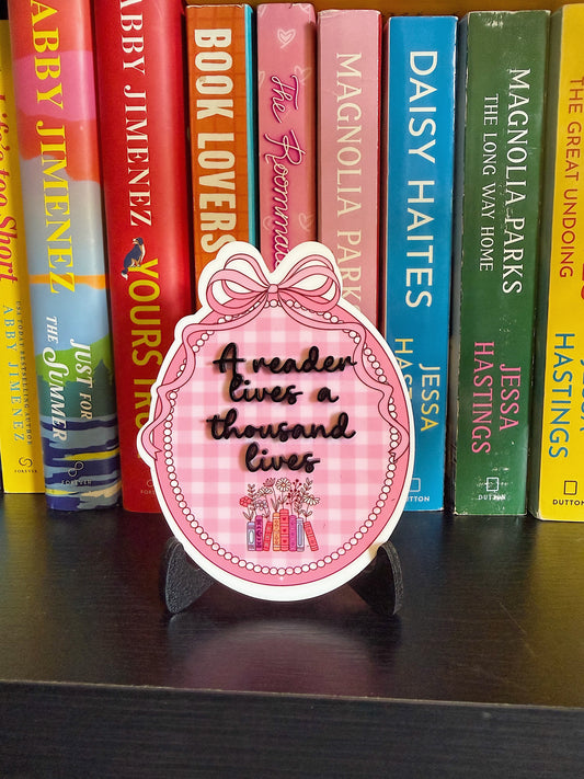 “A reader lives a thousand lives” bookshelf sign